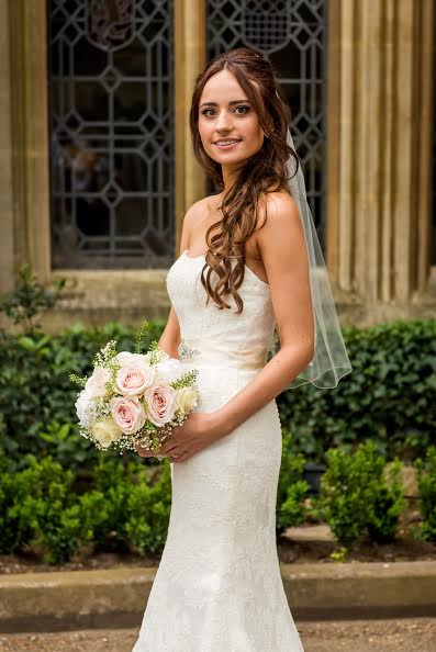 London Bride outside holding a bouquet in hair and makeup.