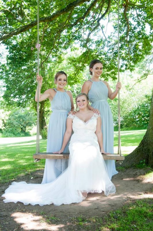 A bride poses with her bridesmaids with makeup by Solihull Makeup Artist